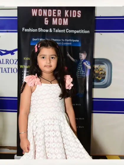 This young model-in-training looks lovely in her white lace dress, ready for her audition.