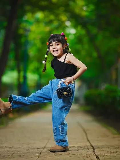 A fun, energetic shot of a little girl kicking up her heels on a park pathway. Outdoor shoots are perfect for capturing personality.