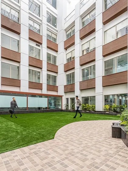 The courtyard at Sarvesh Health City, surrounded by the building's facade, offers a protected green space for patients and staff. This design ensures that a connection to nature is always just a few steps away.
