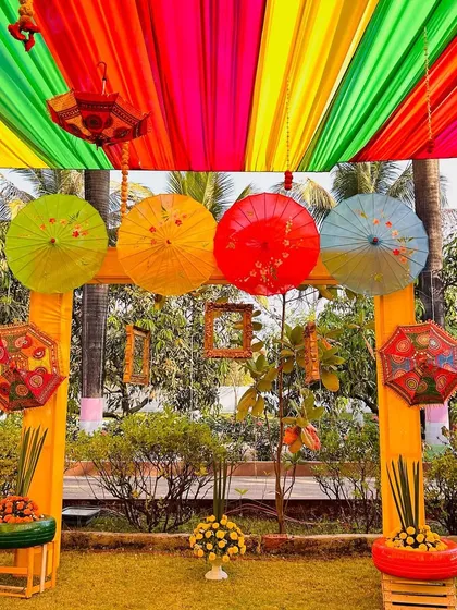 This photobooth for a Mehendi ceremony uses colorful umbrellas and traditional Rajasthani decor elements. The multi-hued ceiling drapes add to the festive, carnival-like atmosphere of the event.