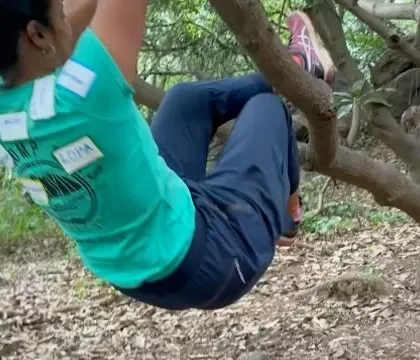 It's not all serious climbing. A participant enjoys a playful moment, hanging from a tree branch during a break at our workshop. We believe in having fun and enjoying the outdoors together.