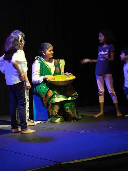 A quiet, narrative moment from a children's play. This scene demonstrates the range of emotions and stories our students can portray, from high-energy dances to thoughtful character interactions.