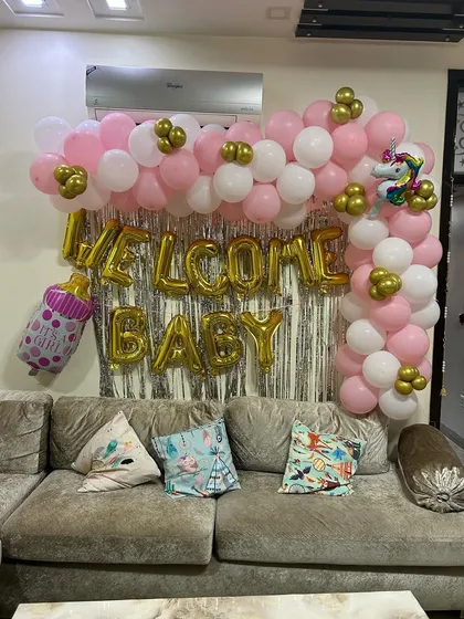 A wider shot of the welcome baby balloon arch. This view shows how the decoration fits perfectly above a standard sofa, making it an ideal choice for apartment living rooms.