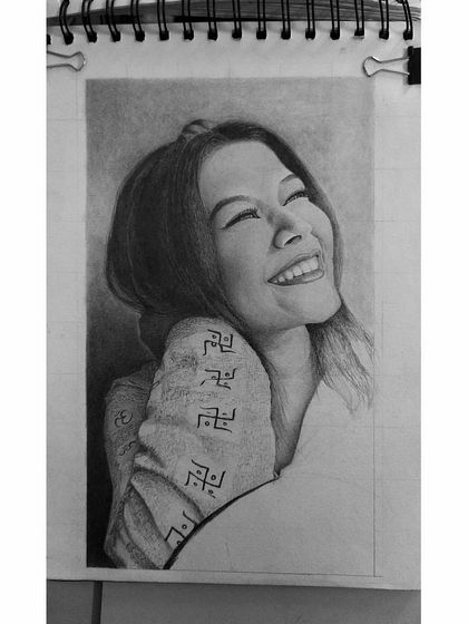 The laughing woman portrait in progress. This shows how I build up layers of graphite to create smooth skin tones and capture the shape of the face.