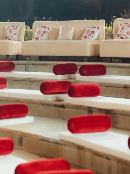 A clean, minimalist approach to guest seating at the amphitheater. We used simple white cushions with striking red velvet bolsters, creating a sharp, elegant contrast against the stone steps of the venue.