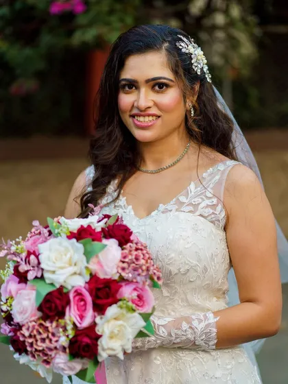 A close-up portrait with her bouquet. Her smile is the best accessory, enhanced by a makeup look that is soft, pretty, and timeless.