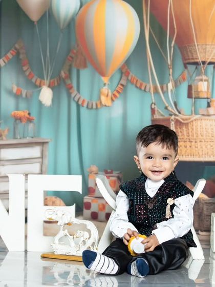 This one-year-old is celebrating his birthday with a travel-themed party, complete with hot air balloons and vintage suitcases.