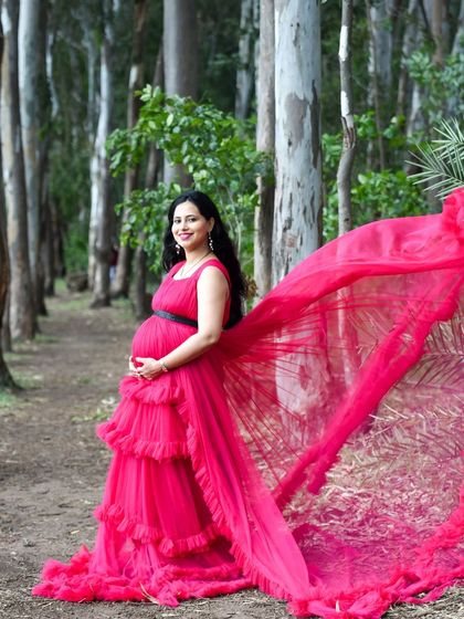 A beautiful shot in the woods, with the mom-to-be in a striking pink gown. The fabric flows behind her, creating a sense of movement and grace among the trees.