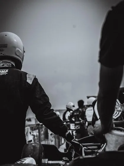 A black and white shot of a driver on the grid.