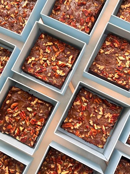 Rows of our fudgy pecan brownies, ready to be boxed up for a baby announcement bulk order. A rich and decadent treat to share with loved ones.