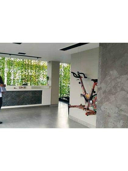 The reception area at Chakra, featuring a clean, minimalist counter against a backdrop of a vibrant green wall. This space provides a fresh and welcoming first impression for members entering the studio.