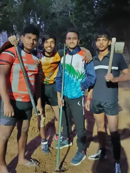 A group of our dedicated players with the tools of the trade, both for playing and for preparing the ground.