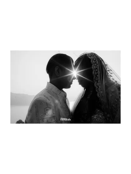 A silhouette of the couple against the sun, creating a starburst effect where their foreheads meet. A magical, symbolic shot of two souls aligning.