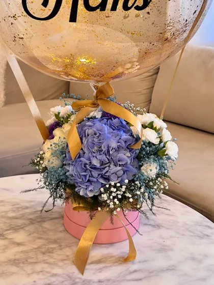 The final look of the hot air balloon arrangement, tied together with a gold ribbon that complements the glitter inside the balloon.
