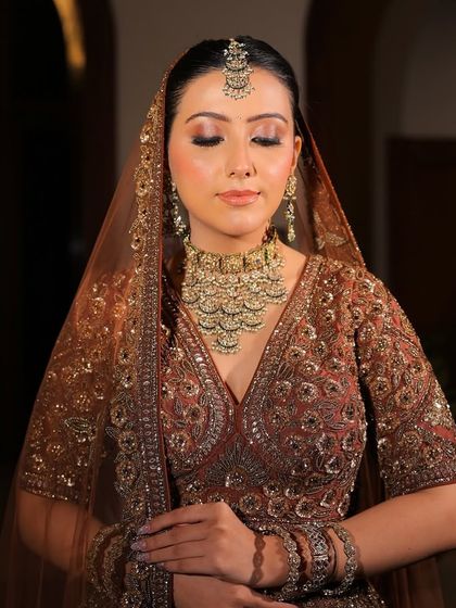 A serene moment, with the bride's eyes closed, highlighting her flawless makeup and the stunning bridal choker.