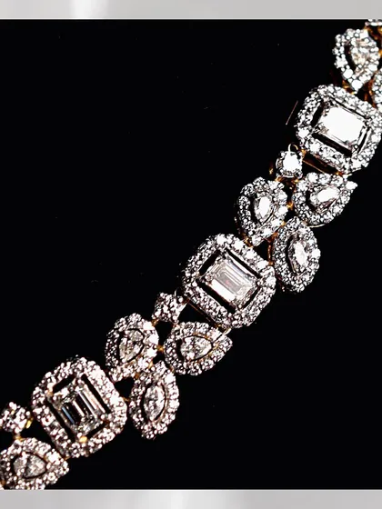 A detailed view of the collar-bone necklace, showing the precise arrangement of the emerald-cut and fancy-shaped diamonds. This level of detail is a hallmark of my bespoke designs.