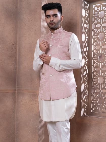 A three-quarter view of the rose pink bundi set. The asymmetrical cut of the white kurta adds a modern touch to the soft, traditional aesthetic of the embroidered jacket.