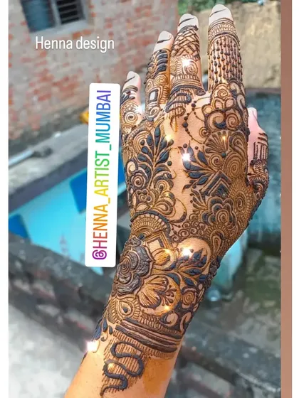A full-hand design that incorporates a snake motif along the wrist, blending with traditional floral and geometric patterns. This is a great example of custom storytelling.