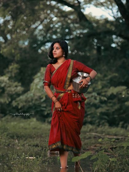 A rustic, village-themed series inspired by the movie 'Kanthara'. The model is styled in a simple red saree, captured in a natural, watery landscape to evoke a sense of raw, earthy beauty.