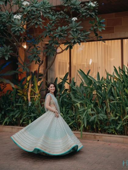 A beautiful shot of the bride twirling in her light blue lehenga, capturing a moment of pure grace and happiness during her Sangeet.