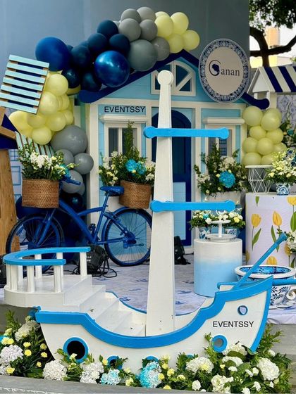 This shot highlights the themed props, including a miniature boat, a bicycle with a flower basket, and a wooden windmill.