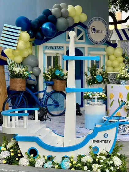 This shot highlights the themed props, including a miniature boat, a bicycle with a flower basket, and a wooden windmill.