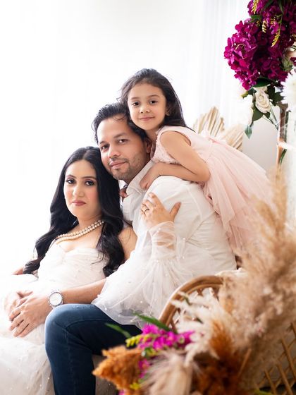 A lovely family portrait taken during a maternity session. The daughter perched on her dad's back adds a playful and natural feel to the photo.