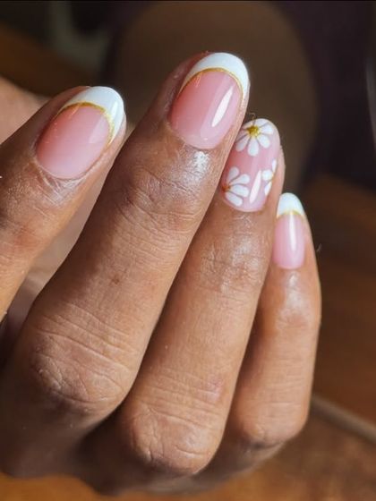Short Frenchies with a cute twist. This design features a classic white tip with a gold accent line and a hand-painted daisy on one nail.