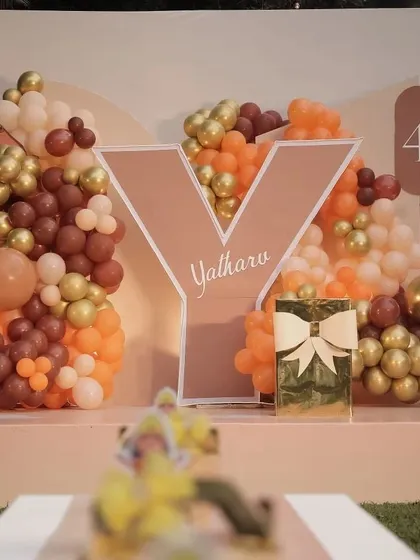 A personalized decor element for a Bala Hanuman themed party. The large initial 'Y' for Yatharv, set against a backdrop of earthy-toned balloons, creates a perfect photo spot.