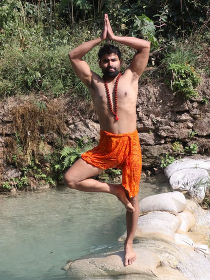 Performing Tree Pose in a natural, serene environment. Practicing yoga outdoors helps deepen the connection between the body, the mind, and the natural world around us.