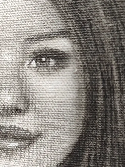 A macro shot of the Selena Gomez portrait, showing how the graphite and charcoal interact with the canvas weave.