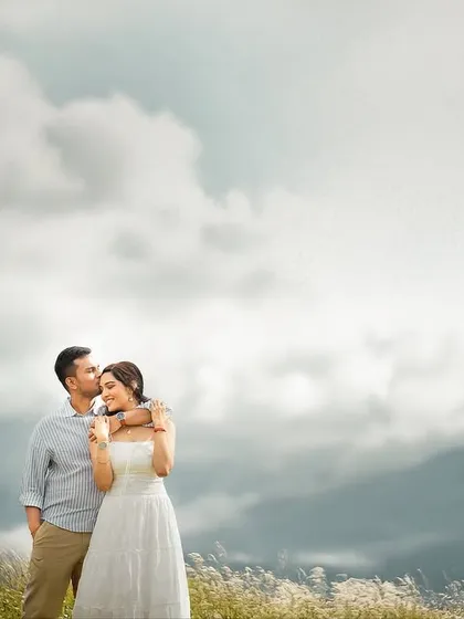 An intimate embrace against a backdrop of clouds resting on the mountains. I use my 85mm lens to create this soft, compressed background, making the couple the clear, emotional focus of this romantic portrait.