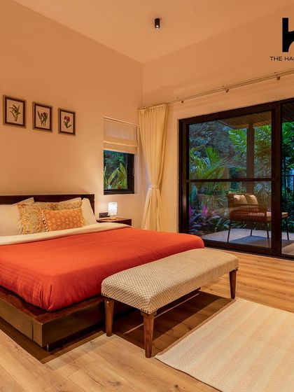 Another bedroom in the villa, designed with simplicity and comfort in mind, featuring a sliding glass door that leads to a private outdoor space.