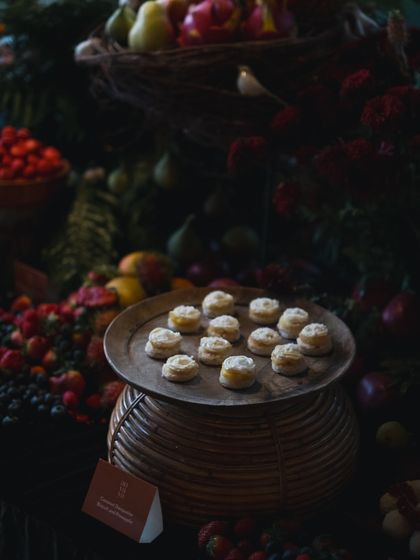 A close-up of delicate pastries on a rustic wooden platter, part of a larger, indulgent spread. Each bite is a carefully crafted masterpiece.