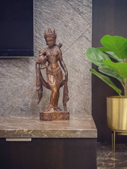 Details matter in creating a refined space. Here, a traditional brass sculpture sits on the Italian marble countertop of the TV unit, its warm tones complemented by a modern brass planter, blending classic and contemporary decor.