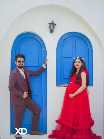 A stylish couple posing against the popular Santorini-style blue doors, exuding confidence and joy.