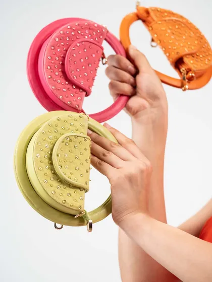 My Candy Floss mini bags are all about having fun with fashion. This image shows a few of the vibrant, playful colours available, each with a unique circular handle and delicate stud detailing.