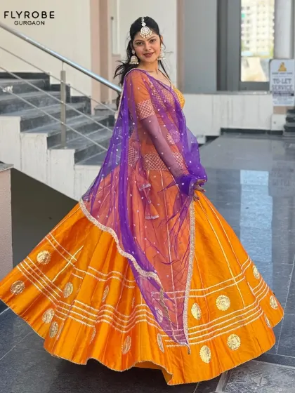 Influencers love my collection, and you will too. This vibrant orange and purple lehenga is a perfect example of the unique, eye-catching pieces I offer for rent.