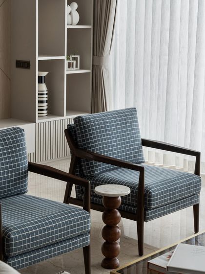 These armchairs, with their dark wood frames and checked upholstery, bring a touch of timeless English style to the living room. They provide comfortable seating while adding a classic design element to the space.