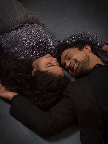 An artistic and intimate top-down shot of an expecting couple. This creative angle captures a quiet, shared moment of peace and connection.