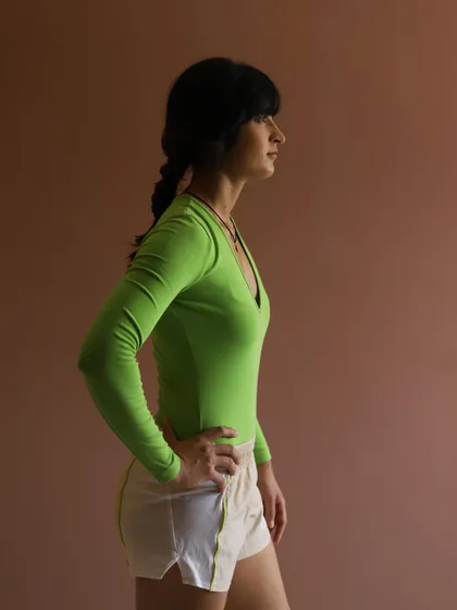 A simple, strong portrait against a neutral background. This shot highlights the model's athletic physique and the fit of the apparel.