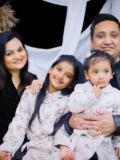 A beautiful posed shot of the family of four, with the little one looking curiously at the camera.