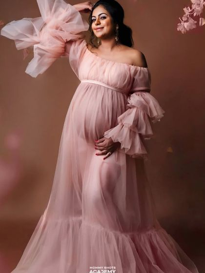 An elegant portrait in a flowing pink tulle gown, showing a dreamy and romantic style.