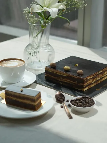 My Opera Cake, served by the slice or as a whole cake, is perfect for any celebration. It's pictured here with a fresh cup of coffee.