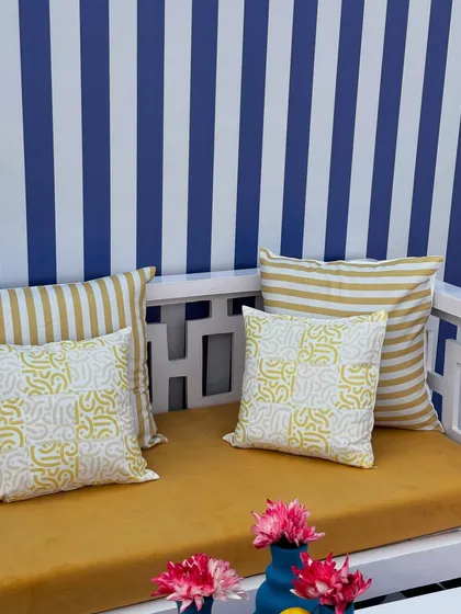 A close-up of the custom seating at our Uttarayan event. The mustard yellow cushions are paired with pillows featuring both striped and abstract patterns, tying the whole modern theme together.