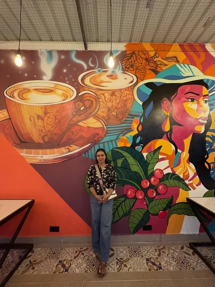 Here I am with the completed coffee-themed mural. It was a huge project, and I'm so proud of how my team and I brought this design to life.