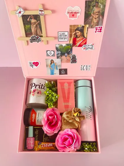 Inside the Valentine's box, a fully customized gift with a personalized mug and flask, perfume, chocolates, and a photo collage on the lid.