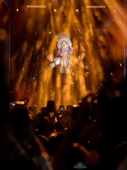 I use dramatic lighting and smoke effects to create a divine and powerful atmosphere. This shot from the Kalachowkicha Mahaganpati Aagman captures the idol emerging through golden light, a moment of pure devotion that my production is designed to enhance.
