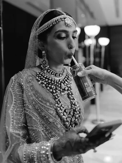 A cool bride taking a moment for a drink and a scroll. We manage the chaos so you have moments to breathe, relax, and just be yourself.