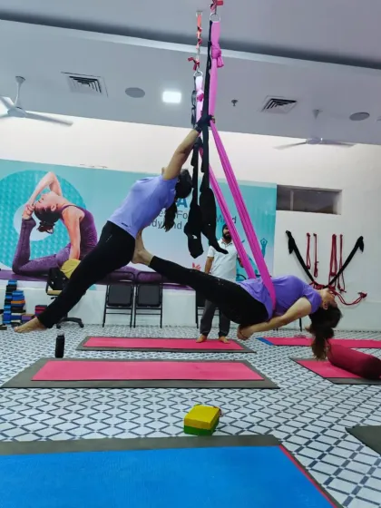 This split-leg aerial pose demonstrates the incredible flexibility and strength that can be developed through consistent practice with the hammocks.